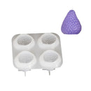 A silicone mold tray with four oval cavities and a small purple strawberry-shaped item shown above it on a plain white background.