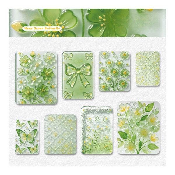 A sheet of decorative stickers or transfer designs featuring green floral and butterfly motifs on a white textured background, with a header reading 'Moss Green Butterfly.' The designs include translucent green butterfly and flower patterns, embossed-style floral panels, and several pale green and yellow botanical prints.