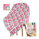 A colorful crocheted granny-square blanket draped over a wooden chair, shown with a small inset of the finished square pattern and a side table holding yarn skeins, a crochet hook, a pattern booklet, and other crafting accessories on a white background.