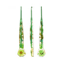 Three green glass crochet hooks with embedded dried flowers and gold foil, shown from front, side, and back views on a white background.