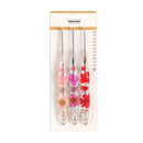 A set of four crochet hooks in a clear plastic blister pack with a white backing card. The handles are decorated with pressed flowers in pink, red, and orange, and the card includes a size chart in millimeters.