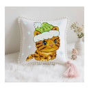 Cross-stitched pillow with a cat design wearing a hat on a white surface.