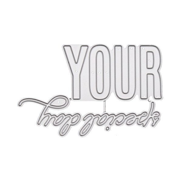 A silver metal die-cut cutting template with the words 'YOUR happy accident' in raised block and cursive lettering, shown on a plain white background.