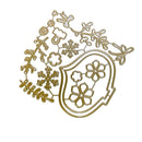 A gold metal die-cut craft sheet featuring winter-themed designs including snowflakes, pinecones, leaves, and a shield with floral motifs, isolated on a white background.