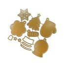 A set of gold-colored metal die-cut craft shapes featuring Christmas motifs, including a snowflake, Christmas tree, mitten, stocking, bell, and cloud outline, arranged on a plain white background.