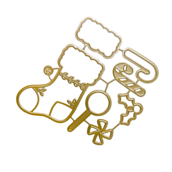A gold-colored metal holiday die-cut cutting template featuring a Christmas stocking, candy cane, cloud shape, snowman, candy cane, holly, and bow outlines, displayed on a clean white background.