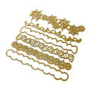 A set of gold metal embossing or cutting dies arranged diagonally on a plain white background, featuring various Halloween-themed designs including spiderwebs, bats, and skulls.