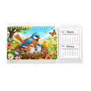 A spiral-bound desk calendar shown open to display the 2027 January and February pages, with a colorful diamond painting style illustration of a bluebird family in a nest surrounded by flowers and butterflies on the cover.