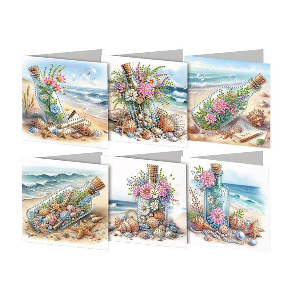 Six beach-themed greeting cards arranged in two rows on a white background. Each card features an illustrated scene with glass bottles filled with flowers and starfish, surrounded by seashells and sand, with ocean waves in the background.