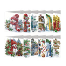 A set of eight Christmas-themed diamond painting canvases displayed in two rows. The designs feature festive holiday scenes including snowmen in red hats, decorated Christmas trees, a gingerbread house, a golden archway, wrapped gifts, and snowy cottages with pine trees and evergreen garlands.