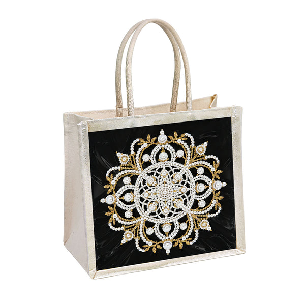 A structured tote bag with a black front panel featuring an ornate white and gold mandala-style embroidered or beaded design, and light beige handles and side panels, shown on a plain white background.