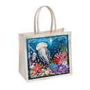 A canvas tote bag with a large, colorful, rhinestone-embellished underwater scene on the front. The design features a white jellyfish, a red starfish, purple and pink coral, and small fish on a deep blue background.