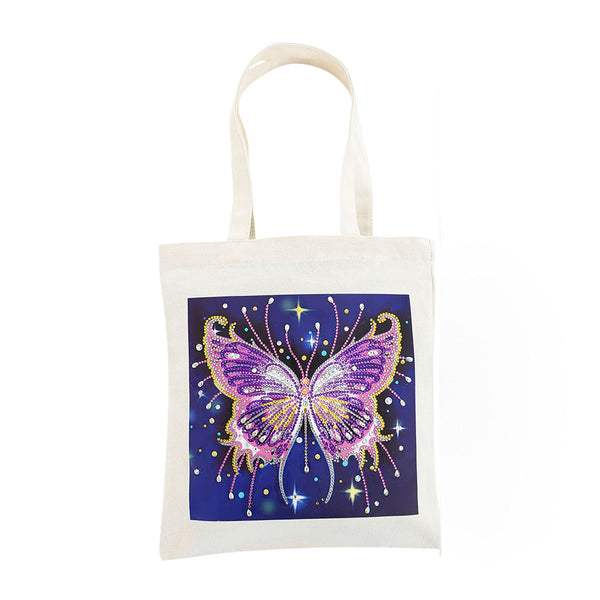 An off-white canvas tote bag with a square graphic print of a glittery purple and pink butterfly on a dark blue starry background.