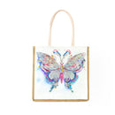 A white canvas tote bag with a natural jute trim and light beige handles, featuring a large, colorful beaded butterfly design on the front.