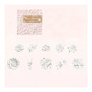White embossed floral nail art stickers arranged on a pale pink background, with a small textured sample card and gold label in the upper left.