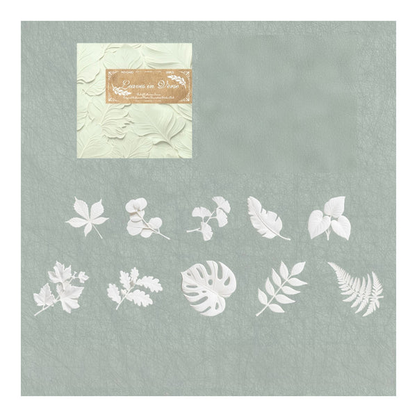 A sheet of white leaf-shaped craft stencils or decals displayed on a textured sage green background, with a small cream envelope and a gold label in the upper left corner.