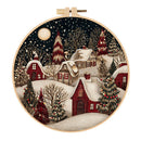 Embroidery hoop with a winter village scene featuring snow-covered houses and trees.