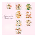 A sheet of decorative stickers featuring watercolor-style mushroom illustrations on a pale pink background. The sheet includes a round sticker with the text 'I WISH I HAD A FLOWER' and the words 'Shimmering Mushroom' printed on the left, plus several irregularly shaped sticker panels with different mushroom designs in beige, green, pink, and blue tones.