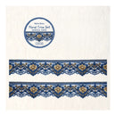 A roll of Retro Story Floral Trim Set tape is shown on a textured off-white background, with two horizontal strips of the blue and gold patterned lace trim displayed below the roll.