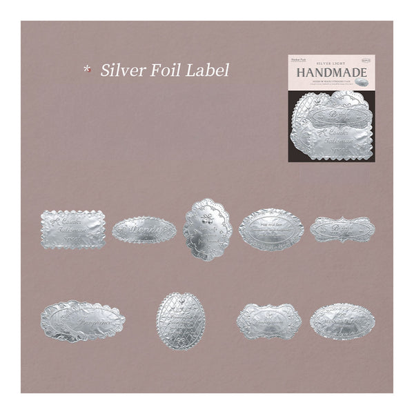 A sheet of silver foil labels with various decorative shapes and scalloped edges, displayed on a dusty mauve background with text reading 'Silver Foil Label' and a small 'HANDMADE' label sample in the top right.