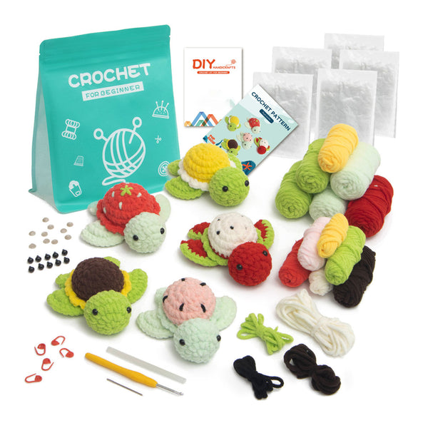 Crochet kit for beginners with a teal bag, yarn balls in multiple colors, three crocheted turtle toys, a DIY booklet, stitch markers, a hook, and other accessories arranged on a white background.
