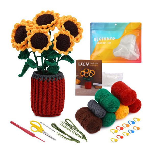 Crochet sunflower kit with a completed sunflower arrangement in a red crocheted pot, plus yarn balls in green, brown, red, yellow, and gray, crochet hooks, scissors, floral wire, and a beginner crochet set pouch on a white background.
