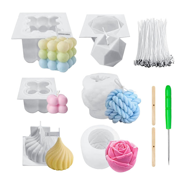 A set of white wax melts and soy wax molds shown on a plain white background, including several geometric and floral-shaped molds, preformed wax pieces in pastel colors, wicks, wooden tools, and a green-handled carving tool.