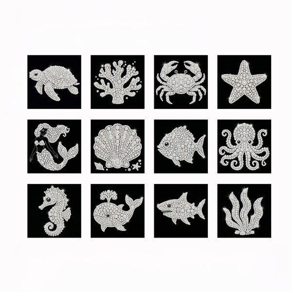 A set of twelve square black tiles, each decorated with a white sea life illustration made of sparkling rhinestones. The illustrations include a turtle, coral, crab, starfish, seahorse, scallop shell, fish, octopus, shark, and kelp.