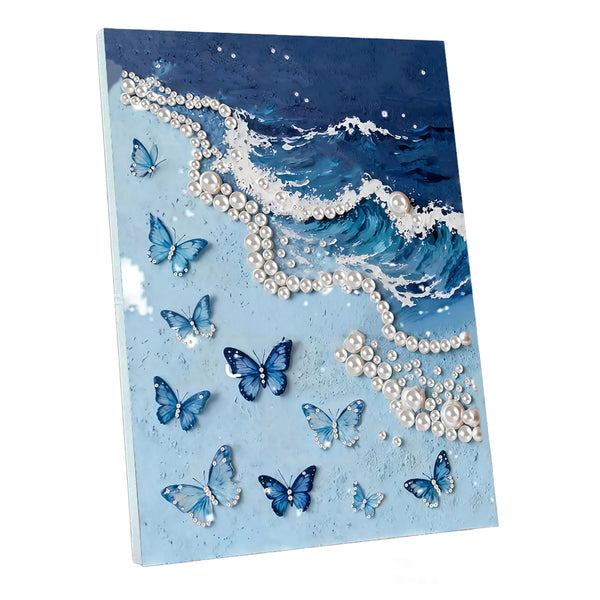 A square canvas wall art print featuring a stylized ocean wave with white pearl-like accents and multiple blue butterflies on a light blue background, shown at a slight angle against a white studio background.