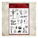 A sheet of clear stamp designs featuring Halloween-themed illustrations including a scarecrow, ghosts, skulls, bats, pumpkins, a spiderweb, a jack-o'-lantern, a haunted house, a tombstone reading 'OPI', and text reading 'Hey Boo!' and 'Trick or Treat!'. The sheet is mounted on a red backing card and photographed against a textured beige background.