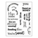 A sheet of clear acrylic or stamp-cut decorative phrases on a white background, featuring black text and script designs such as 'you', 'Sweet as HONEY', 'Magic INSIDE', 'Up, up, & away', 'You are blooming amazing!', 'Sending love', and 'You're sweet'.