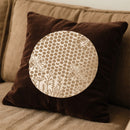 Brown pillow with a circular beige pattern on a beige couch