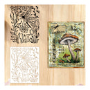 Three decorative stencils with floral, dragonfly, and mushroom designs on a wooden surface.