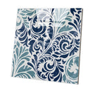 A square decorative tile featuring an ornate baroque-style scroll and leaf pattern in navy blue, teal, and white, shown at an angle on a plain white background.