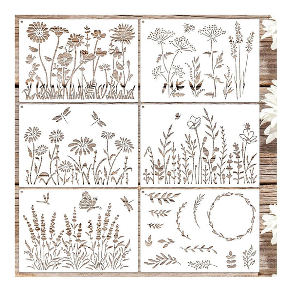 Six square decorative panels with engraved or printed wildflower and botanical line designs, arranged in a 3-by-2 grid on a rustic wood background with white flowers along the right edge.