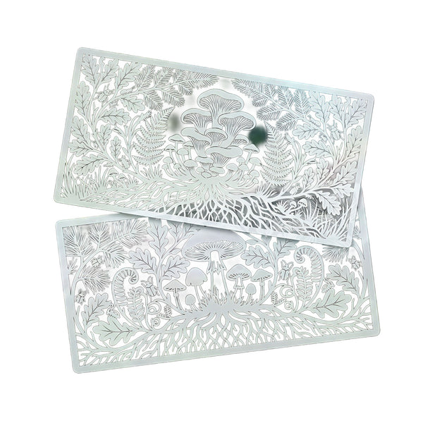 Two rectangular silver metal trays with intricate laser-cut woodland patterns of mushrooms, ferns, and leaves, displayed on a clean white background.