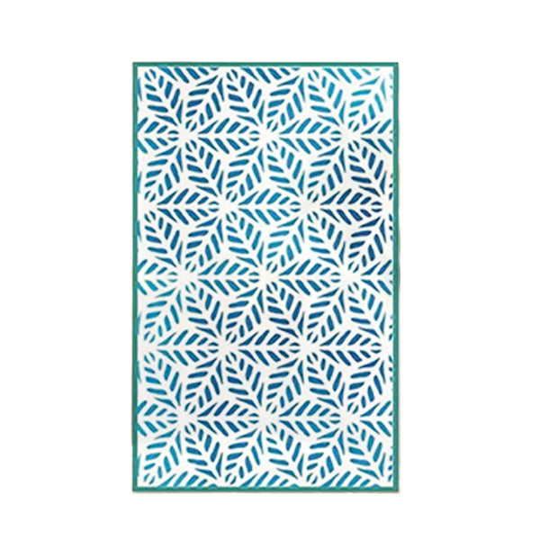 A rectangular area rug with a white background and a repeating blue geometric leaf or snowflake-like pattern, finished with a solid teal border.