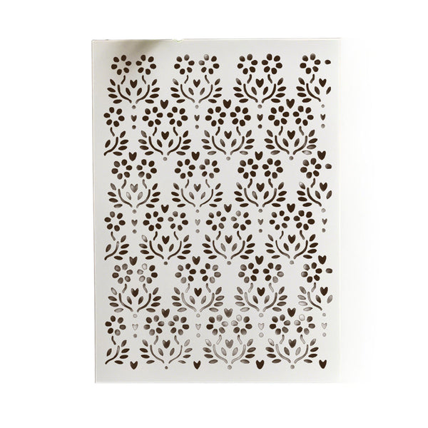 A rectangular white stencil sheet featuring a repeating dark brown floral and leaf cutout pattern, shown against a plain white background.