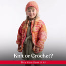 A young girl wearing a chunky hand-knit orange and pink beanie and matching cardigan over an olive green dress, posed against a light gray studio background with the text 'Knit or Crochet? This Yarn Does It All' at the bottom.