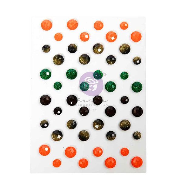 A sheet of round craft gems in assorted colors, including bright orange, emerald green, dark brown, and glittery gold, arranged on a white background with a central watermark.