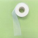 Roll of white mesh ribbon on a green background