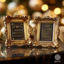 Two ornate gold picture frames with black inserts displaying Hebrew text, styled on a reflective dark surface with a warm, blurred holiday background.