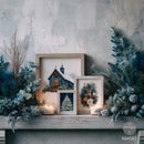 Three framed winter-themed art prints displayed on a rustic wooden mantel, surrounded by blue-green pine branches, frosted eucalyptus, and lit candles against a textured gray wall.