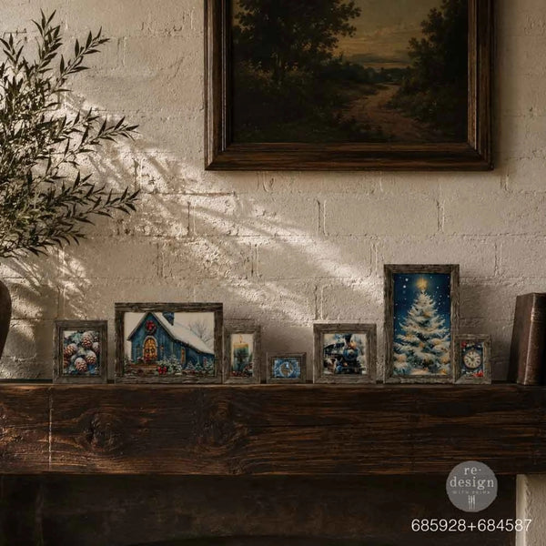 A collection of small, rustic-framed Christmas-themed picture frames displayed on a dark wooden mantelpiece against a textured white brick wall. The frames feature holiday illustrations including a snowy cottage, a Christmas tree under a starry sky, and floral designs.