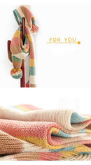 Colorful knitted blanket with a bottle on a white background