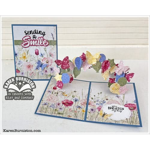 Floral and butterfly card with 'sending a smile' text on a wooden background