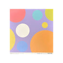 A square paper craft sheet with a pastel abstract pattern of large circles in coral, yellow, orange, light blue, and white on a lavender background, shown against a plain white backdrop.