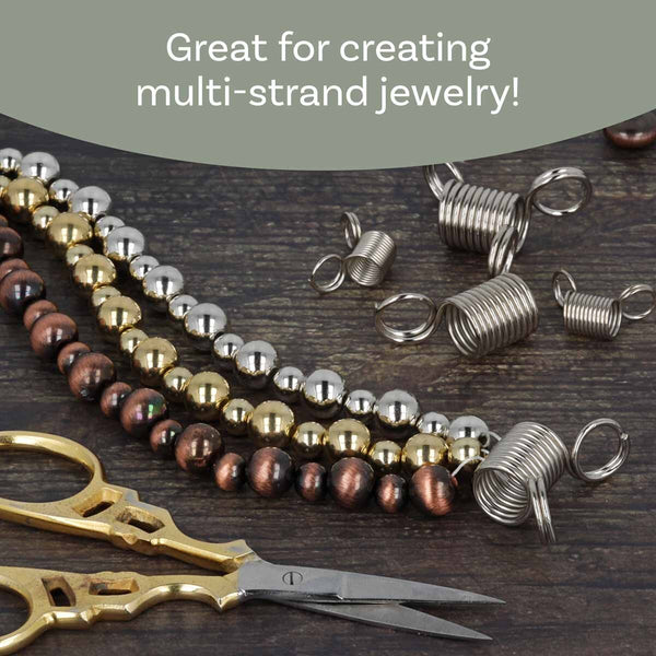 Jewelry making supplies including strands of brown, gold, and silver beads, silver spring clips, and gold-handled scissors on a dark wood background, with a text banner at the top reading 'Great for creating multi-strand jewelry!'.