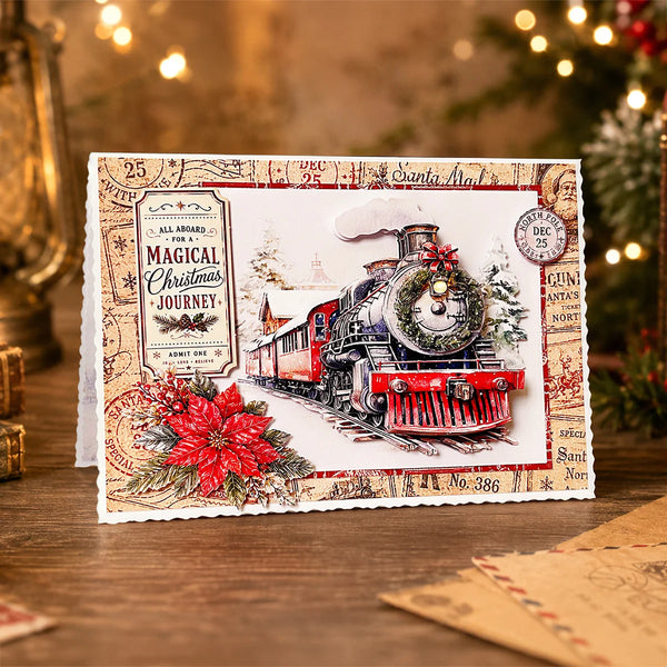 A handmade Christmas postcard featuring a vintage red steam locomotive train, a red poinsettia, and holiday-themed stamp designs, displayed on a wooden surface with a blurred festive background.