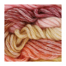 Four twisted yarn skeins in blended warm colors, including dusty rose, pale pink, cream, and peach-orange, arranged vertically on a white background.